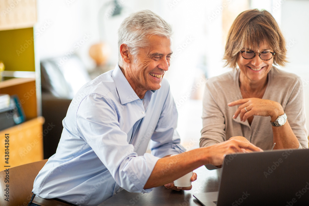 happy older couple sitting with laptop happy older couple sitting with laptop