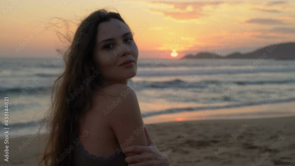 Attractive young woman in dress. Exotic appearance girl mysteriously looks at the viewer. The coast of the Pacific Ocean. Woman plays with hair. Attractive young woman in dress. Exotic appearance girl mysteriously looks at the viewer. The coast of the Pacific Ocean. Woman plays with hair.