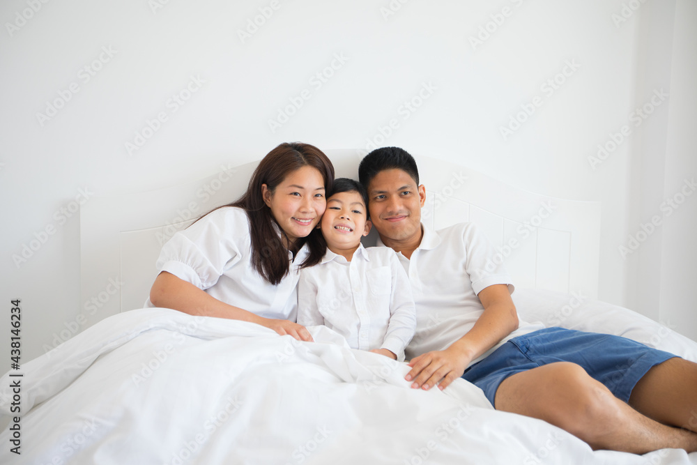 Asian family laying on bed in bedroom with happy and smile Asian family laying on bed in bedroom with happy and smile