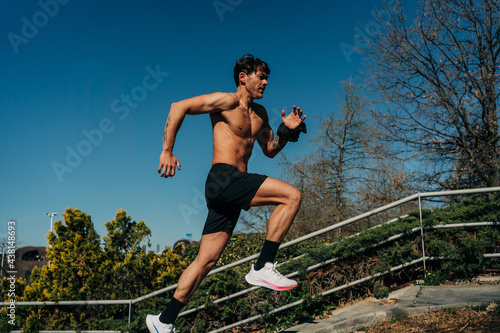 Fast runner jogging on stairs in park photo