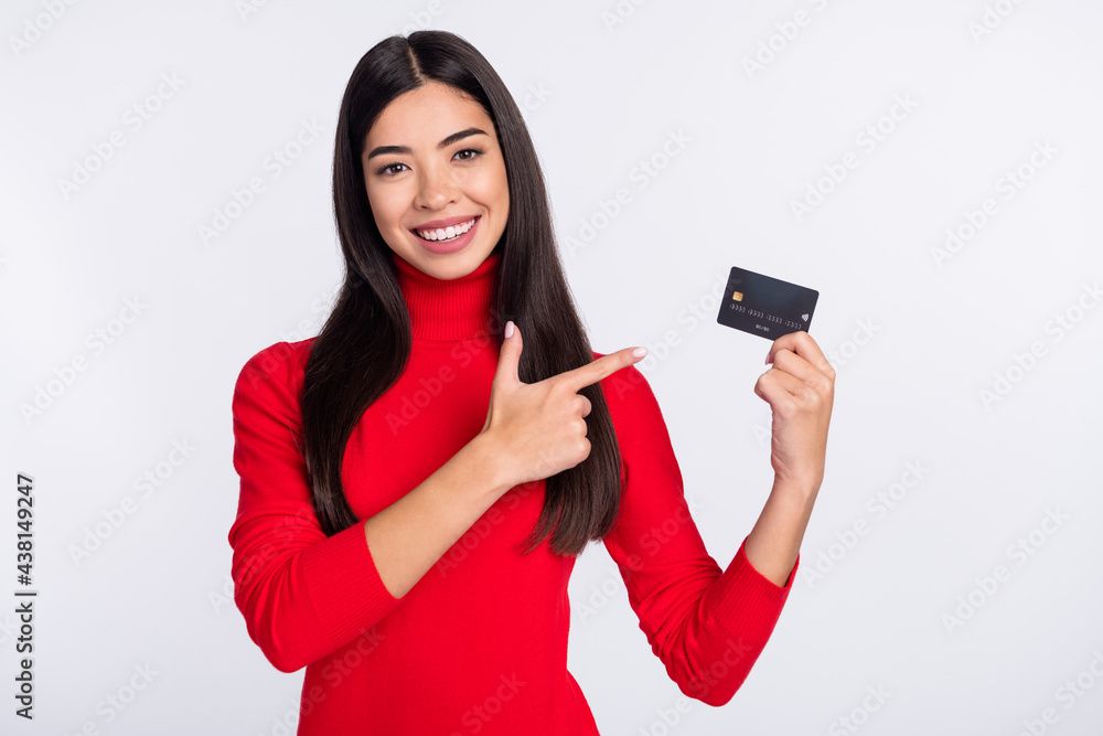 Naklejka premium Photo of young smiling charming positive asian girl advertise credit card recommendation isolated on grey color background