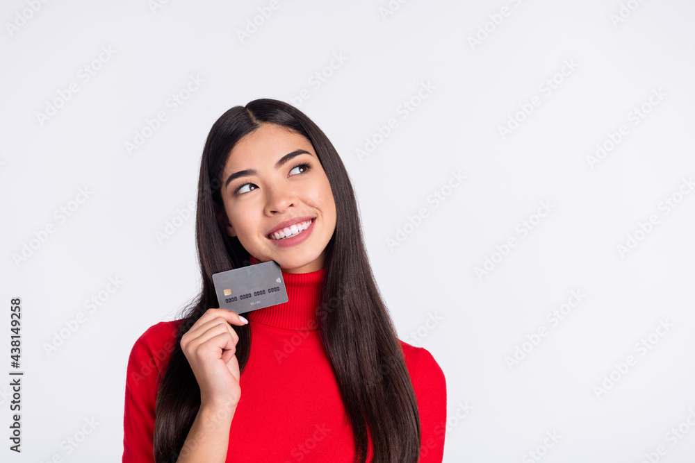 Photo of happy smiling cheerful woman look copyspace dreaming hold credit card isolated on grey color background Photo of happy smiling cheerful woman look copyspace dreaming hold credit card isolated on grey color background