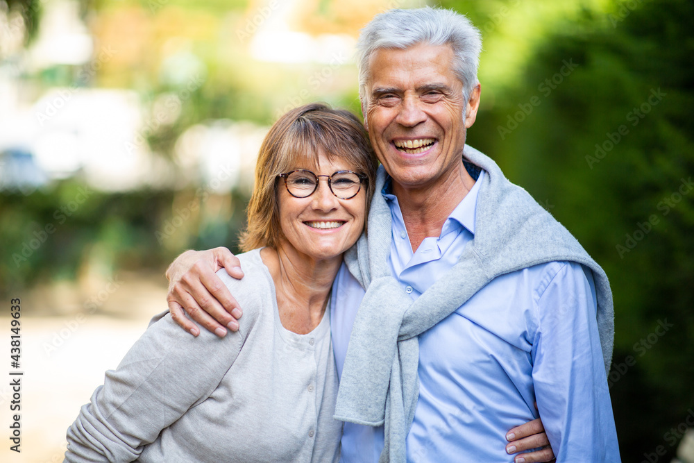 happy mature couple in each other arms outside in park happy mature couple in each other arms outside in park