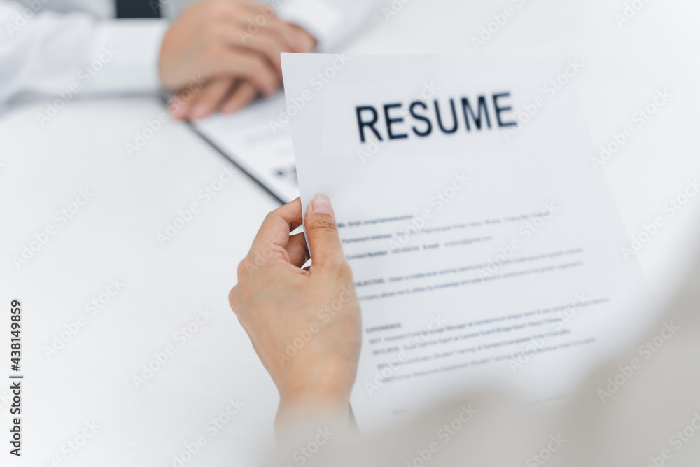 Examiner reading a resume during job interview at office Examiner reading a resume during job interview at office