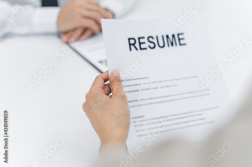 Examiner reading a resume during job interview at office
