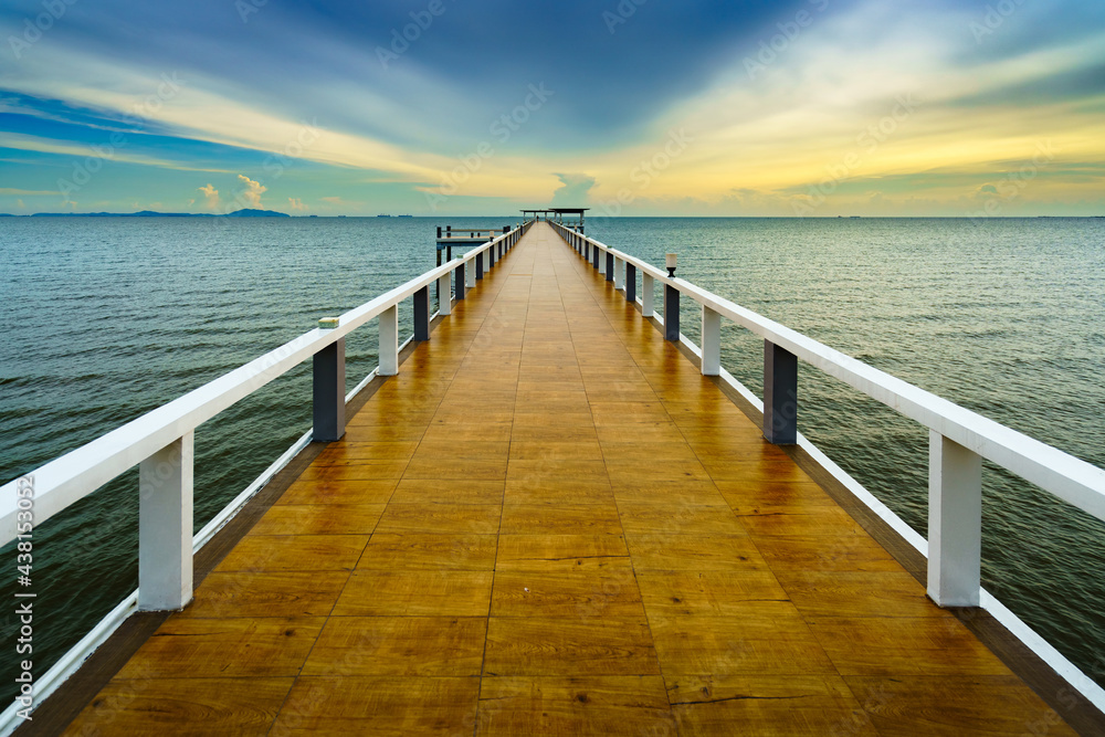 Obraz premium Sea or nature background with sunset and sky at twilight. Perspective view of wood bridge and pavilion. Asia travel destination in Chonburi of Thailand called Bangsaen Beach for holiday and vacation.