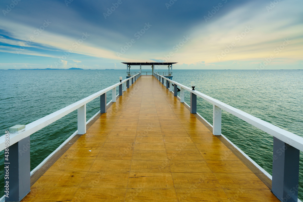 Sea or nature background with sunset and sky at twilight. Perspective view of wood bridge and pavilion. Asia travel destination in Chonburi of Thailand called Bangsaen Beach for holiday and vacation.