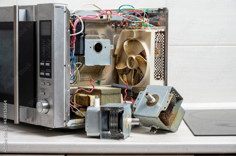 New and old magnetrons next to the disassembled microwave Photos | Adobe  Stock