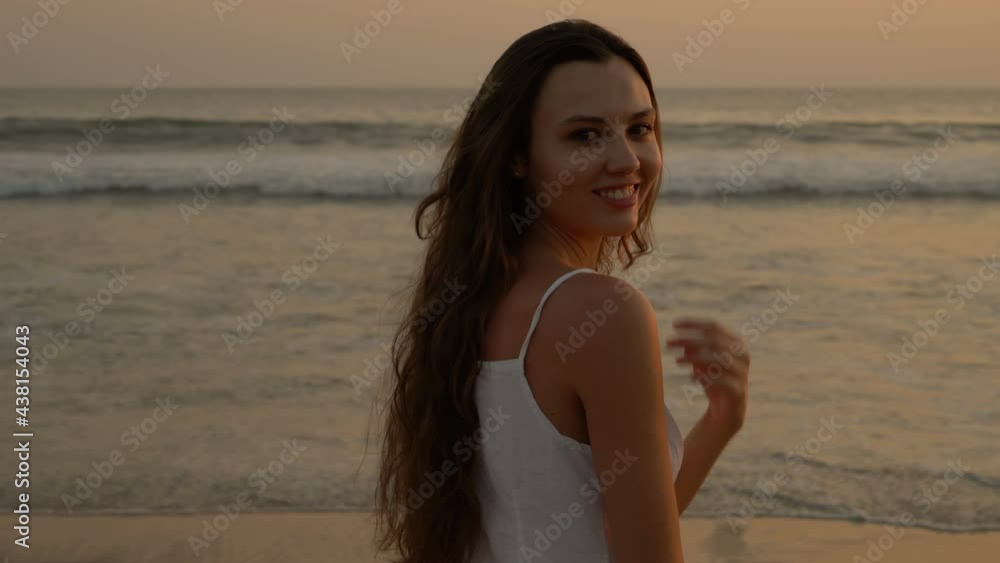 Attractive young woman in white dress. The girl mysteriously looking at the viewer. The coast of the Pacific Ocean. Woman plays with hair. Attractive young woman in white dress. The girl mysteriously looking at the viewer. The coast of the Pacific Ocean. Woman plays with hair.