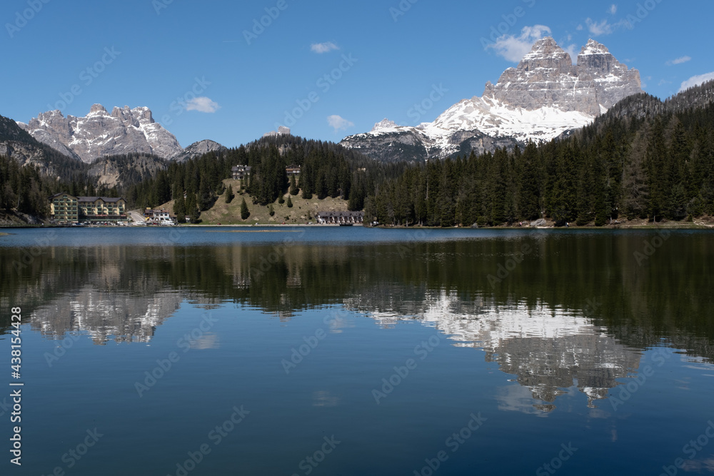 Misurina, Italy - May 31, 2021: The fabulous alpine lake in the Dolomites. Lovely and relaxing place in the Italian Alps. Reflections in the rippled water. Sunny spring day.