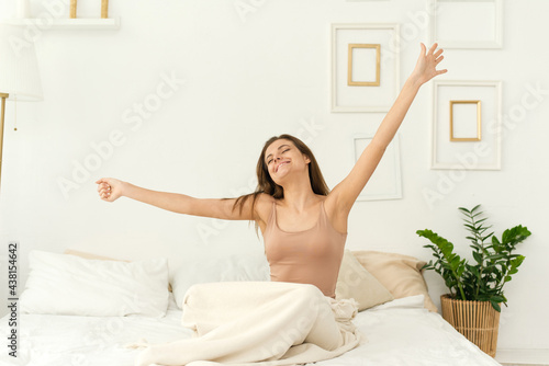 Wallpaper Mural A beautiful woman wakes up in her bed, she smiles and stretches. Green plant next to the bed. Lifestyle Torontodigital.ca