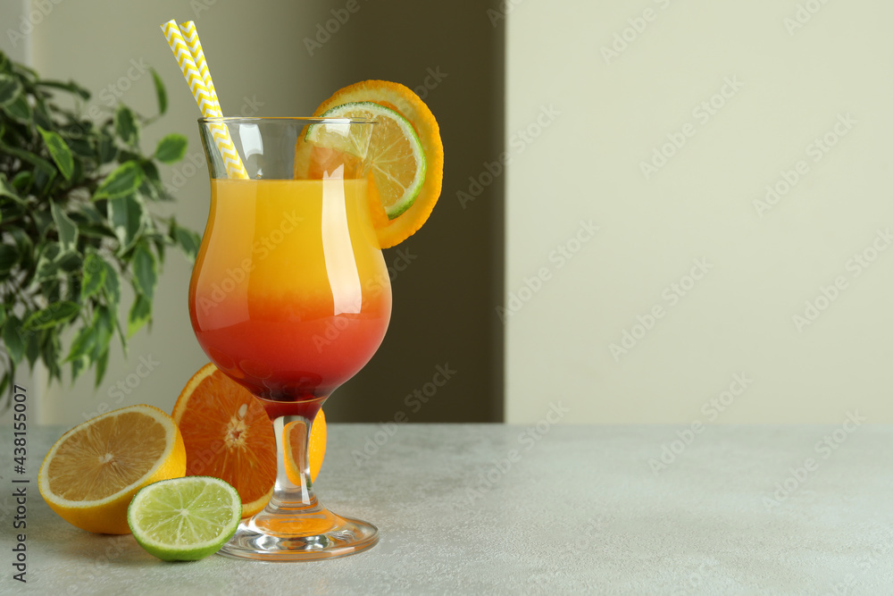 Tequila sunrise cocktail and ingredients on white textured table Tequila sunrise cocktail and ingredients on white textured table