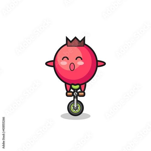 The cute cranberry character is riding a circus bike