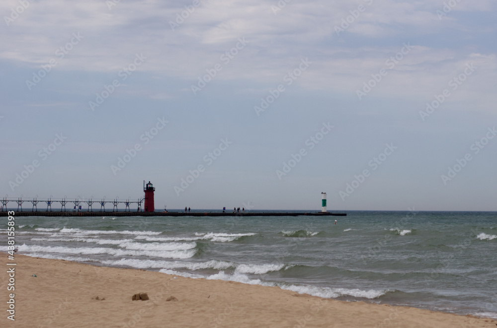 Perspective of two lighthouses on a pier from the beach