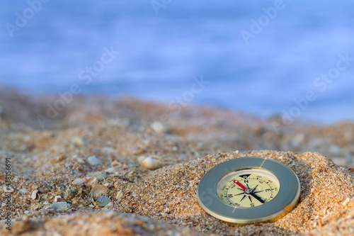 Compass lies on the sea coast, close-up.