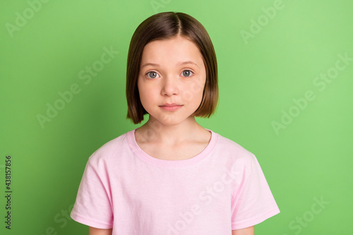 Photo of young attractive lovely school girl happy positive smile focused isolated over green color background
