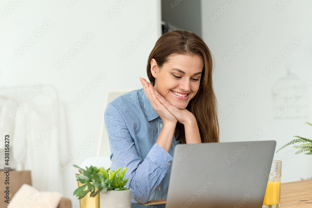 Happy woman communicates with a friend using a laptop and video calling at home. Education learning, communication and lifestyle concept Happy woman communicates with a friend using a laptop and video calling at home. Education learning, communication and lifestyle concept