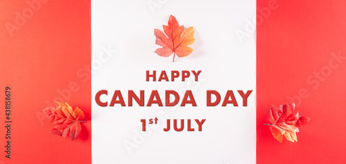 Happy Canada Day concept made from red silk maple leaves with the text on white and red background.