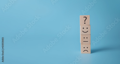 Smile face symbol on yellow wooden cube blocks on blue background and copy space. For improvement and sustainable retention customer satisfaction concept, rating customer review, experience, feedback photo