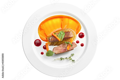Appetizing confit duck breast with pear and yellow apple puree, berry sauce in a white plate. Isolated on white background. View from above