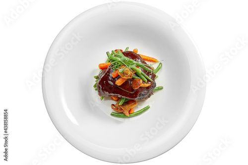 Beef cheek steak, caramelized in wine sauce with chanterelles and asparagus in a white plate. Isolated on white background. View from above