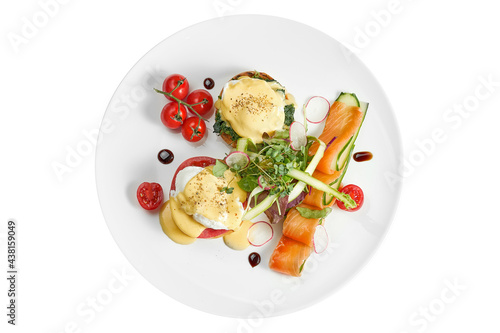 Delicious breakfast with poached egg toast and hollandaise sauce, lightly salted salmon in a white plate. Isolated on white background. View from above photo