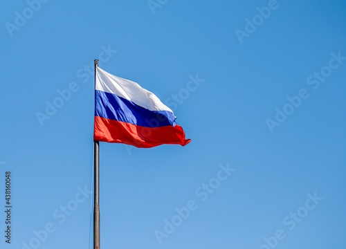 Russian flag waving against the blue sky