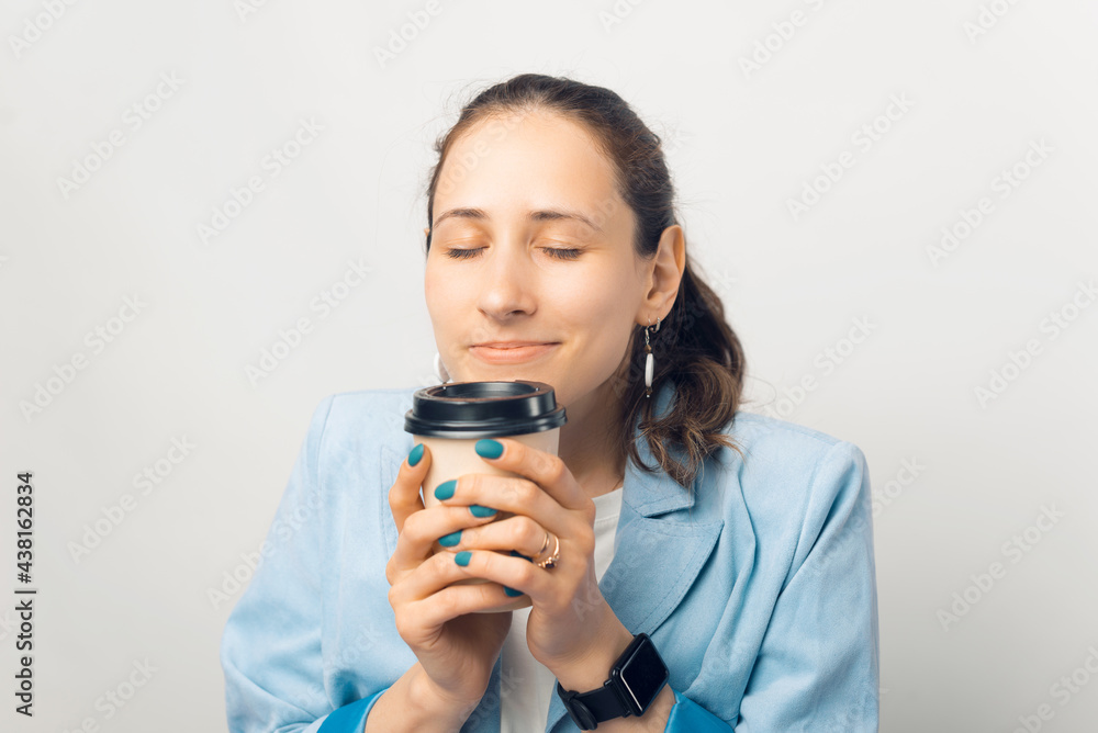 Close up portrait of young woman smelling her morning tasty coffee Close up portrait of young woman smelling her morning tasty coffee