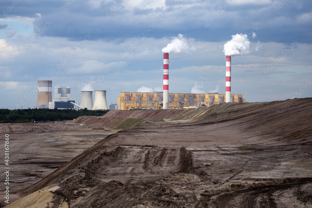 A view of a lignite-fired power plant against the background of an opencast coal mine. Photo taken in daylight. Lots of little clouds in the sky A view of a lignite-fired power plant against the background of an opencast coal mine. Photo taken in daylight. Lots of little clouds in the sky
