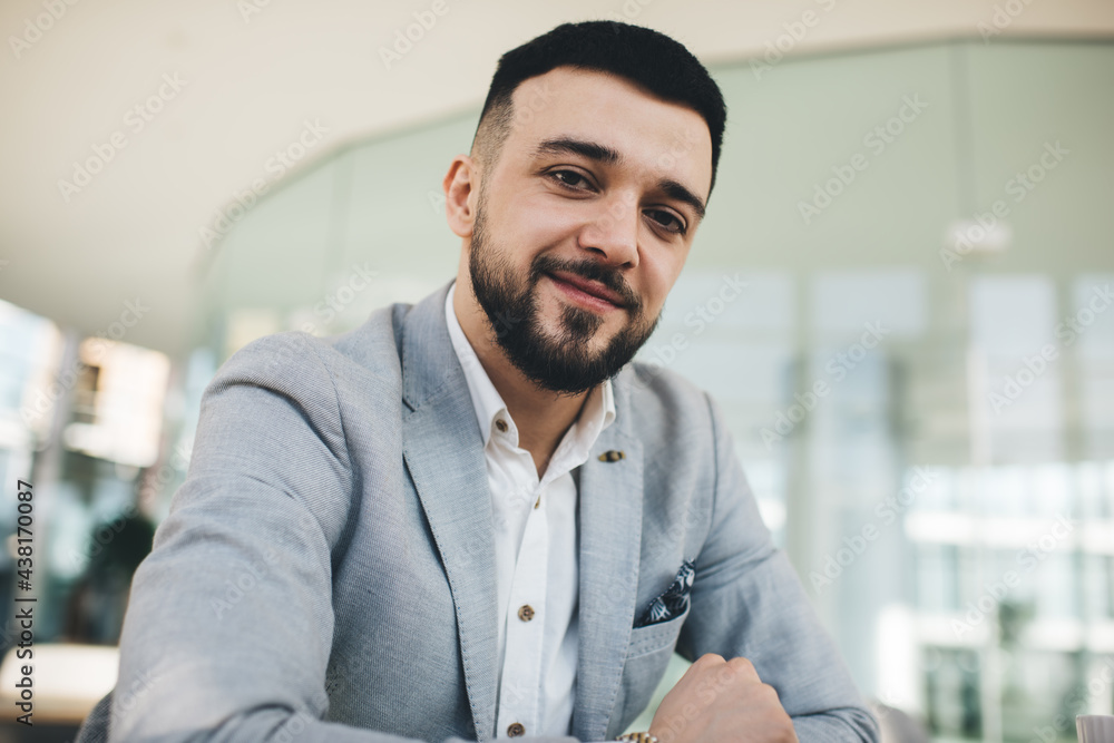 Positive classy young man looking at camera in office Positive classy young man looking at camera in office