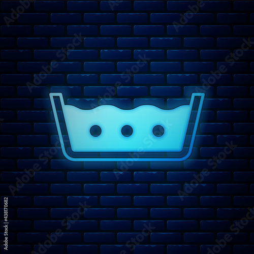 Glowing neon Washing under 50 degrees celsius icon isolated on brick wall background. Temperature wash. Vector