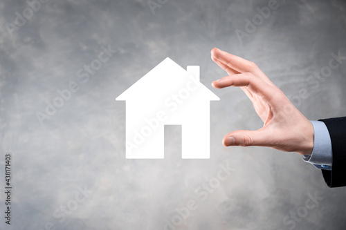 Businessman male hand holding house icon on blue background. Property insurance and security concept.Real estate concept.Banner with copy space.