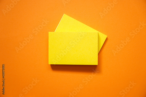 top view of blank yellow notepad on orange paper for background, flat lay.