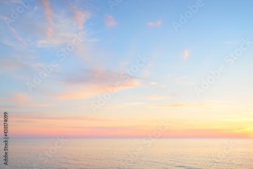 Baltic sea at sunset. Dramatic sky, blue and pink glowing clouds, soft golden sunlight, midnight sun. Picturesque dreamlike seascape, cloudscape, nature. Panoramic view photo