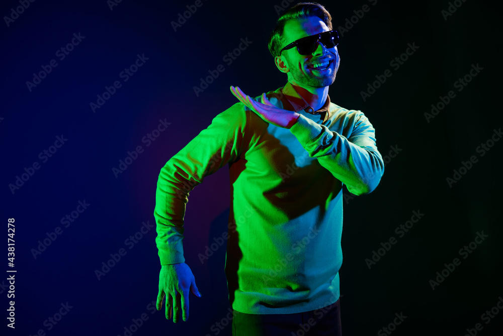 Photo of young funky guy dance wear spectacles sweater isolated on dark blue color background Photo of young funky guy dance wear spectacles sweater isolated on dark blue color background
