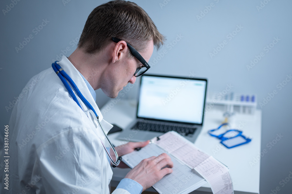 Cardiologist reading an ECG print-out. Doctor analyzing electrocardiogram. Practitioner examine patient test results. Medical and healthcare concept. Physician looking at cardiogram at medical office