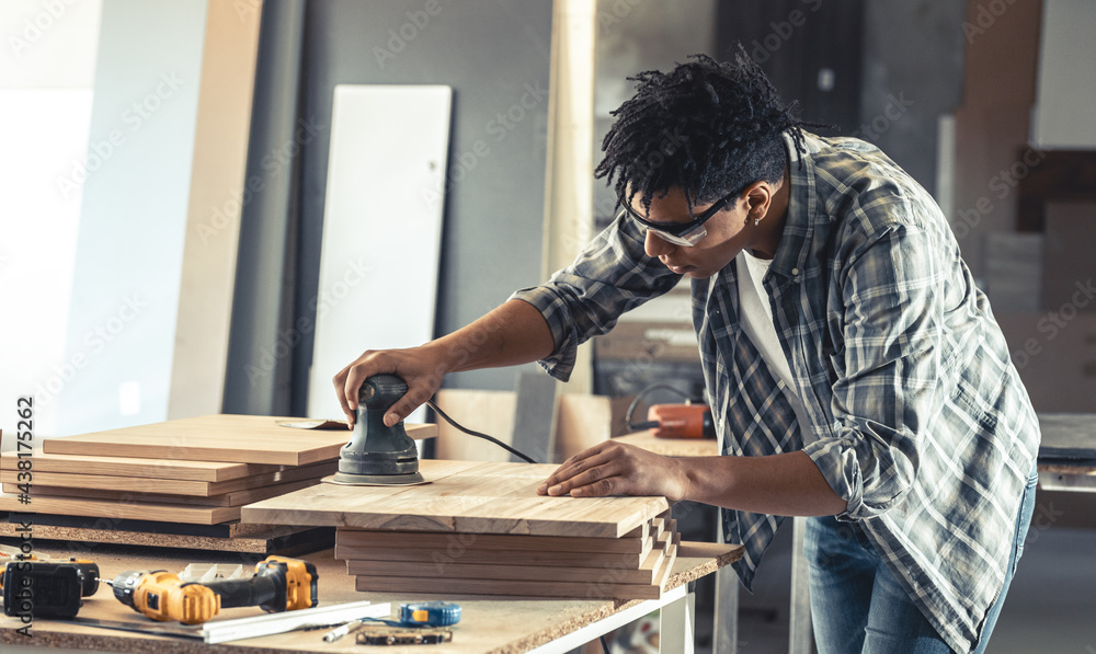 Young carpenter african american man looking and choosing wood and using  sandpaper to rub wooden plank at workshop table in carpenter wood factory  7424164 Stock Photo at Vecteezy