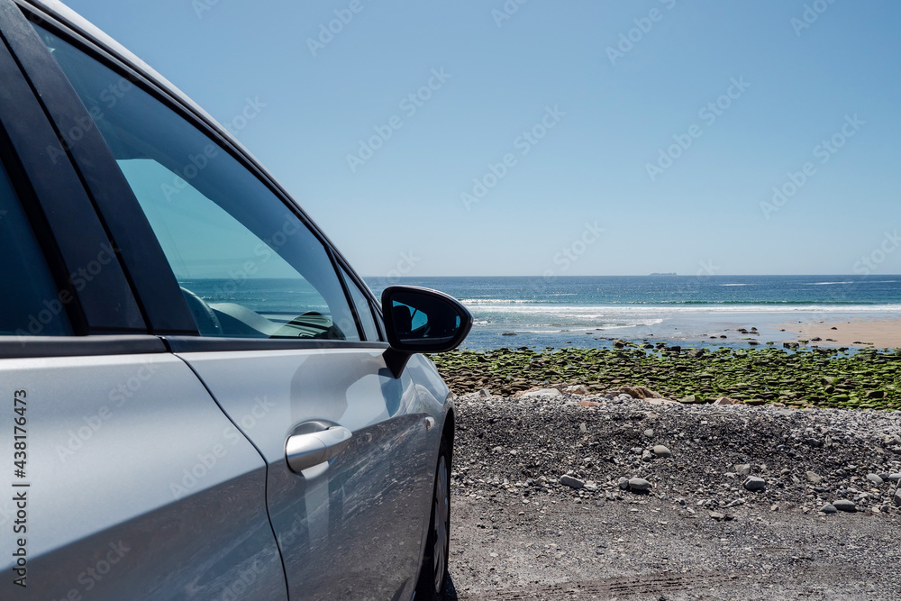Car parked by the ocean view beautiful view on blue water surface. Warm sunny day. Travel and tourism concept, copy space.