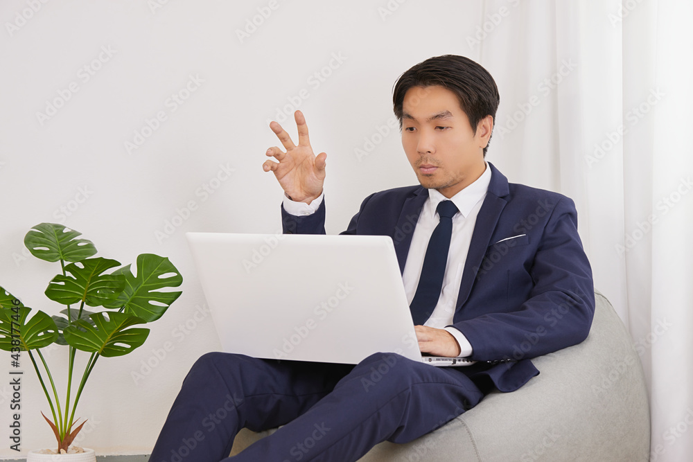 Asian Financial Advisor Video Conference with Customer by Laptop Computer in Home Office. Businessman Work at Home for Social Distance or Home Quarantine in Covid 19 or Coronavirus Situation