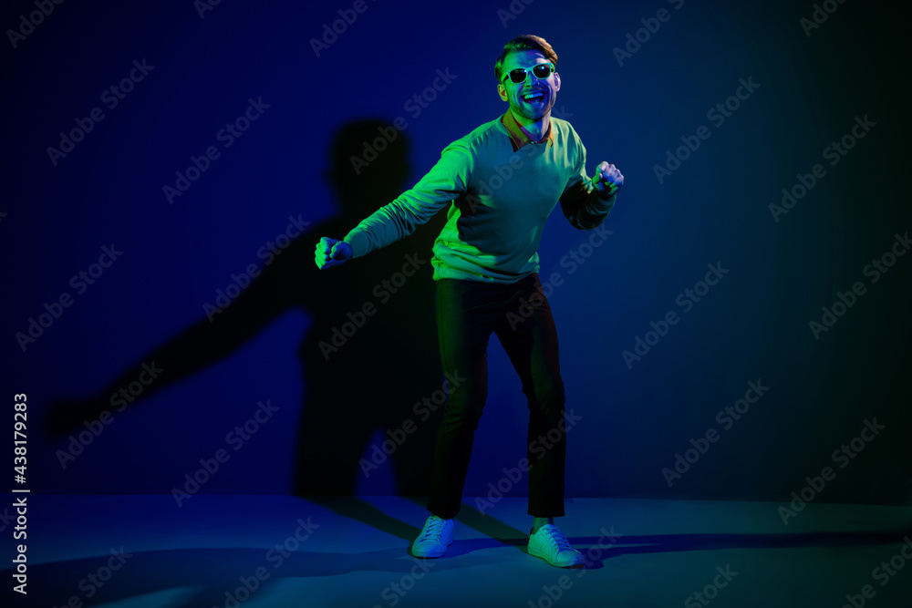 Fototapeta premium Full length body size photo man in sunglass dancing on discotheque chilling on holiday isolated on dark blue color background