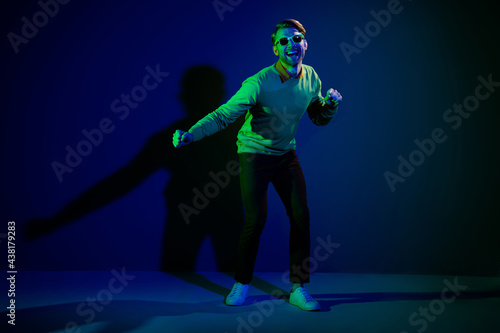 Full length body size photo man in sunglass dancing on discotheque chilling on holiday isolated on dark blue color background