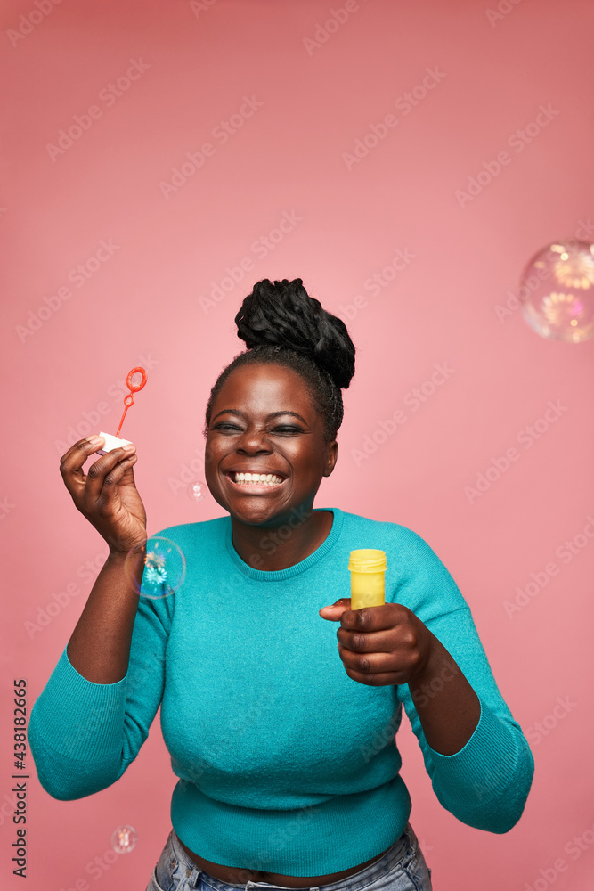 Joyful black woman blowing soap bubbles in studio Joyful black woman blowing soap bubbles in studio