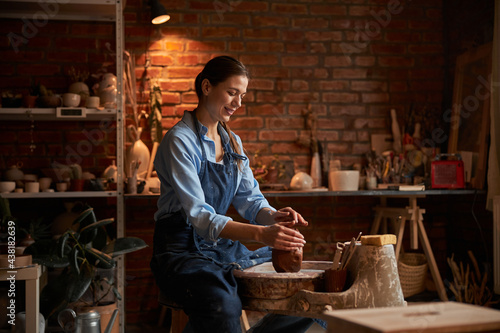Happy attractive craftswoman spending time in art studio at the hobby