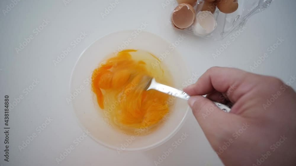 Whisking Egg Yolks With Fork In Bowl Top View With Broken Egg Shells In