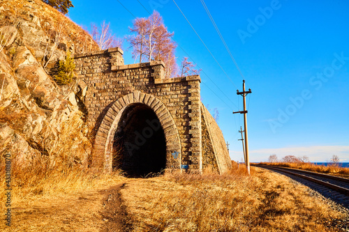 Tunnel on Circum Baikal railway running along the shore of Lake Baikal on an autumn sunny day with a yellow landscape around photo