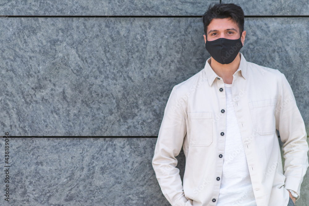 Young man with covid or coronavirus mask leaning against a wall Young man with covid or coronavirus mask leaning against a wall