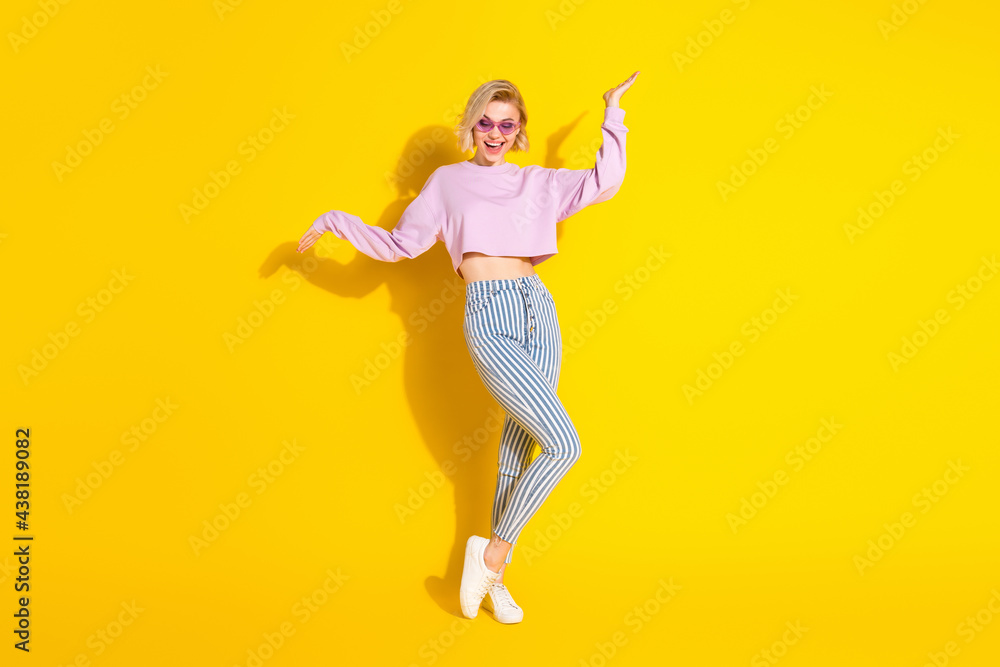 Full length photo of funky positive young woman dance good mood isolated on bright yellow color background