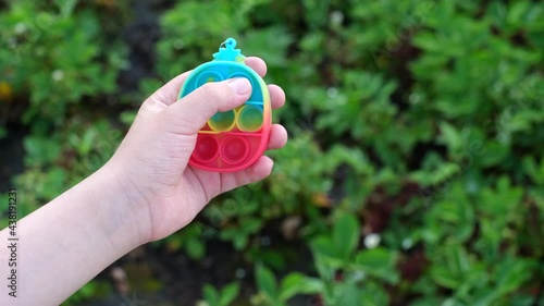 New popular silicone popit toy, baby is playing with it. Rainbow Trendy Pop it fidget toy