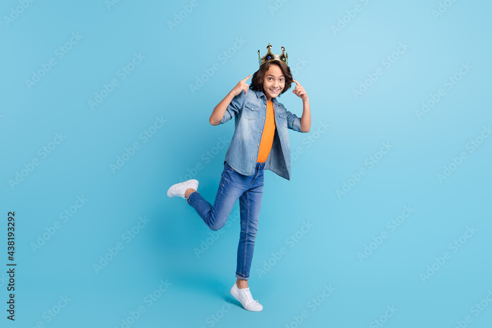 Full length photo of young boy happy positive smile point fingers crown king isolated over blue color background Full length photo of young boy happy positive smile point fingers crown king isolated over blue color background