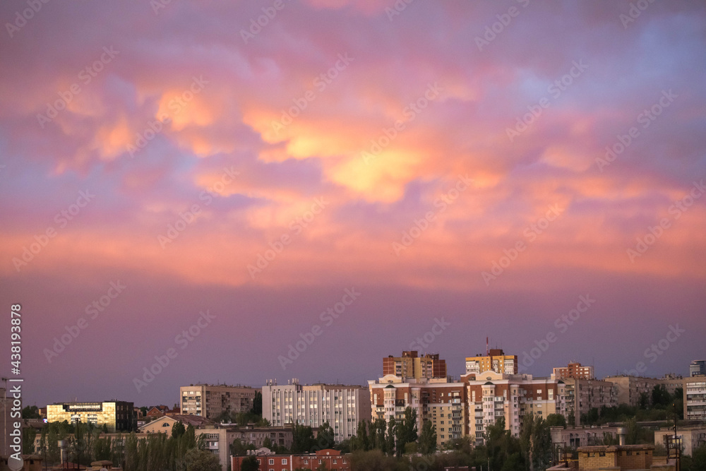 City landscape. High-rise buildings in the clouds. Multi-storey buildings. City. Sunset in the city. Sky with sunset. Pink and gold clouds. The lights of a sun. Dawn. Landscapes. Nature.